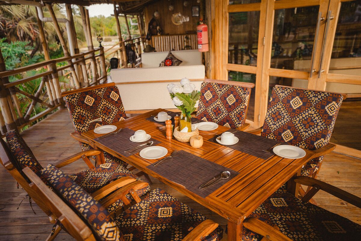 A laid table on the restaurant deck at Cterra Saadani, looking out to the garden